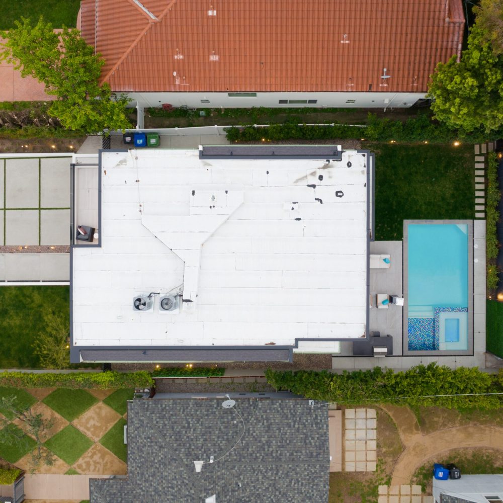 Aerial view of a house and pool in a residential area