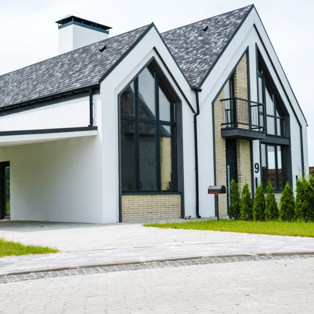 new modern and luxury home with windows and doors near green grass